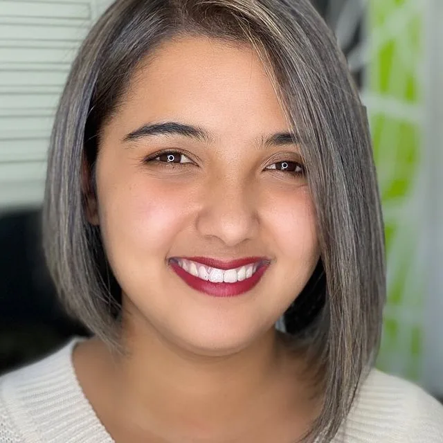 Client with a grey-blended blunt bob, in the Pharaoh salon in front of the green feature wall